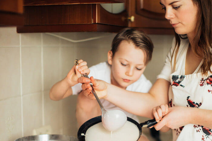 Photo of mother with young son making breakfast